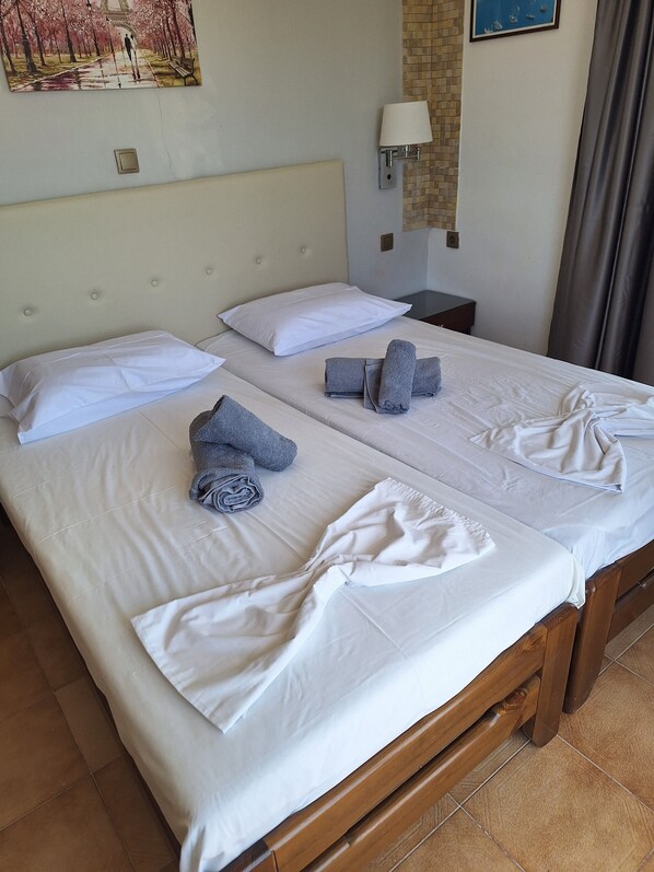 A hotel room with two beds, white linens, and towels.