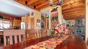A dining area with a long wooden table, wooden chairs, and a decorative centerpiece. - Solitude Village at Okemo  by Vail Resorts (Ludlow)