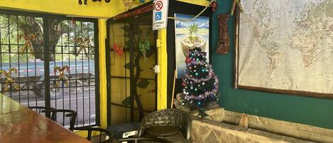 A restaurant interior with a yellow wall, a Christmas tree, and a world map.