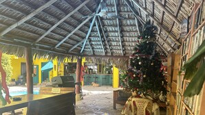 Un espace extérieur abrité, doté d’un plafond en bois, d’un sapin de Noël, d’un barbecue et d’une piscine.