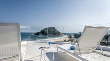 Una piscina al aire libre, sombrillas, sillones reclinables de piscina