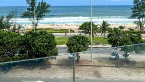 A view of a beach with a road in the foreground, a clear sky, and a calm sea. - CDesign Hotel (Rio de Janeiro)