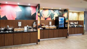 A buffet area with a counter, food display, and a refrigerator. - Fairfield Inn & Suites by Marriott Houston Pasadena (Pasadena)
