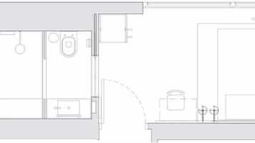 A floor plan of a hotel room with a bathroom, a kitchenette, and a seating area.