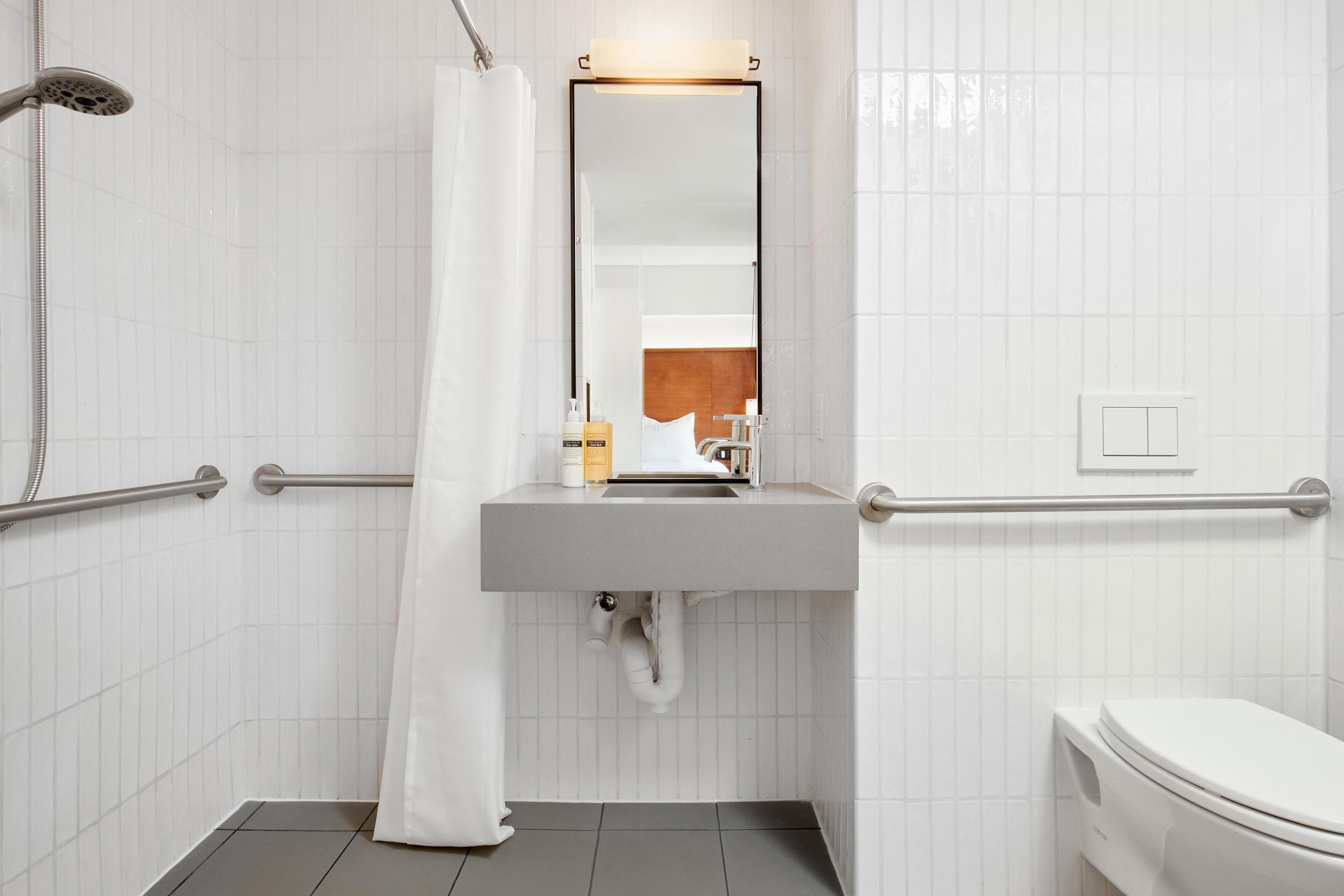 Une salle de bain avec une douche, un lavabo et des toilettes.