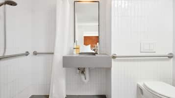 Une salle de bain avec une douche, un lavabo et des toilettes.