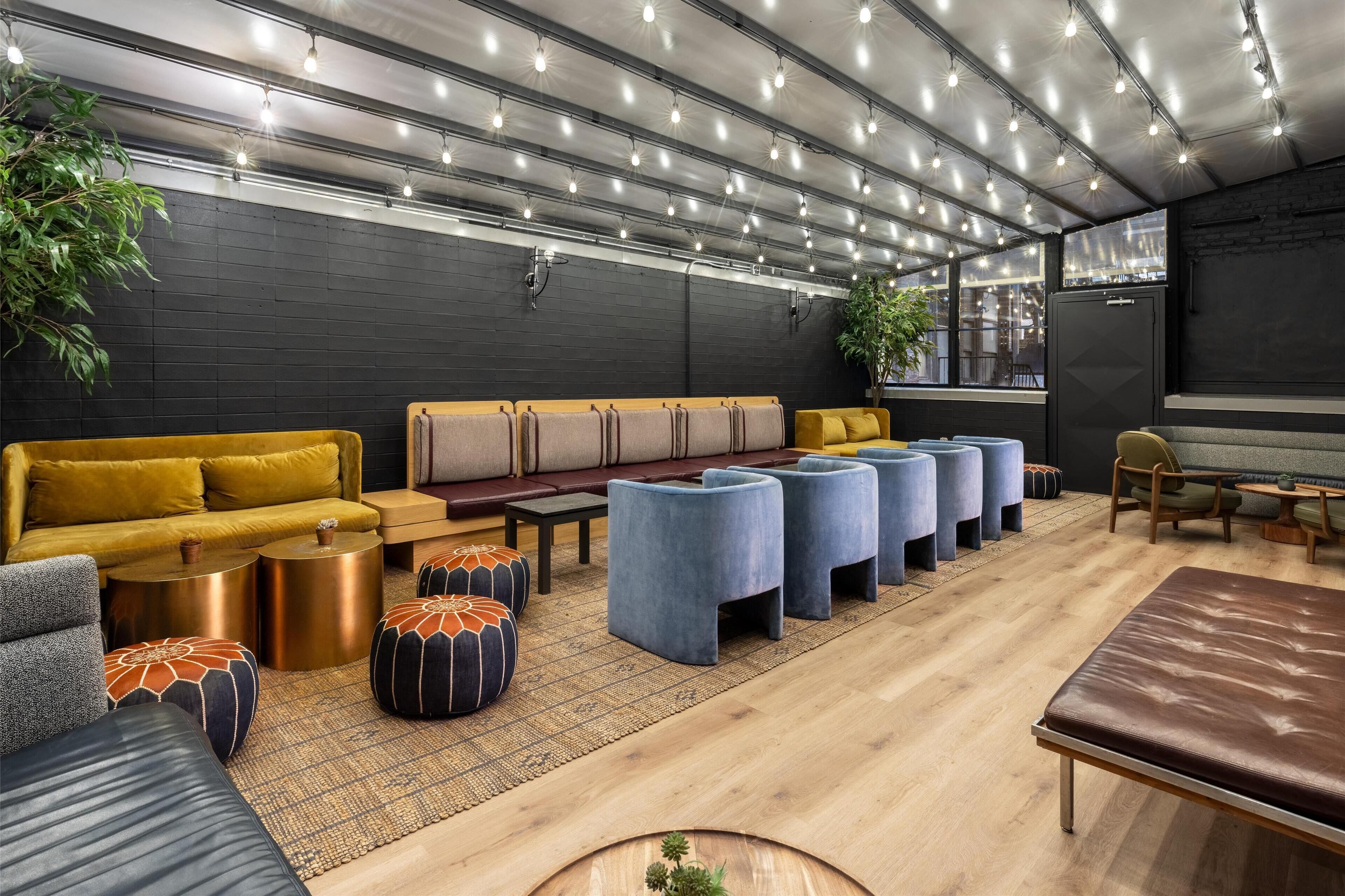 Un espace de détente moderne avec des canapés, des poufs et une table basse en bois.