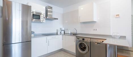 A modern kitchen with stainless steel appliances, a dishwasher, and a microwave.