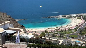 Une station balnéaire dotée d’une plage, d’un port de plaisance et d’une route menant à la plage.