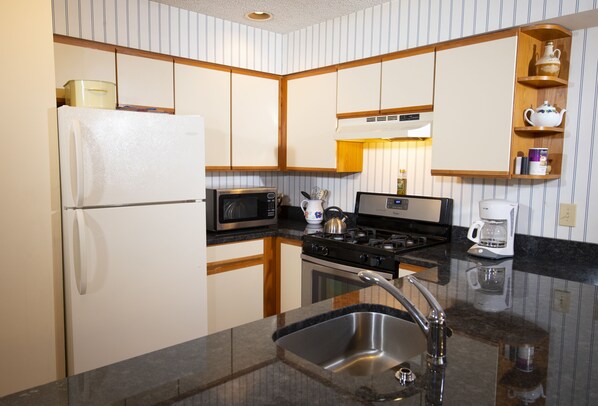 A kitchen with a refrigerator, microwave, stove, sink, and coffee maker. - Winterplace at Okemo, A Vail Resorts Property (Ludlow)