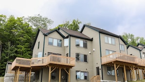 A multi-story residential building with wooden balconies and a stone foundation. - Winterplace at Okemo, A Vail Resorts Property (Ludlow)