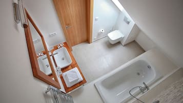 Un baño moderno con tocador de madera, una bañera grande y un inodoro.