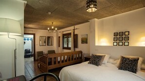 A bedroom with a bed, a wooden bench, a dining table, and a chair. - Casa Bons Aires - Adults Only (Alcoy)