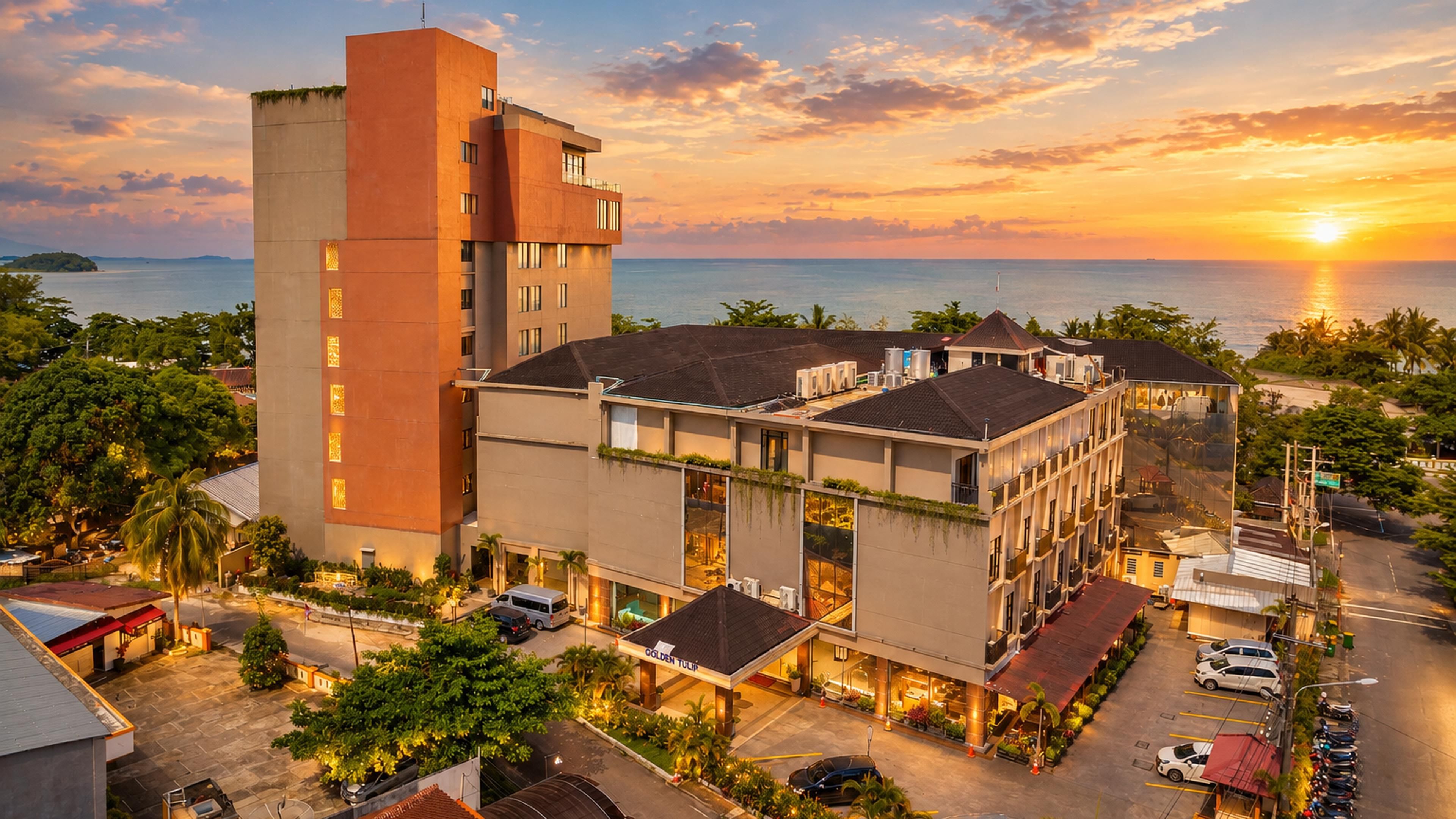 A hotel with a modern design, featuring a prominent tower and multiple buildings with large windows.
