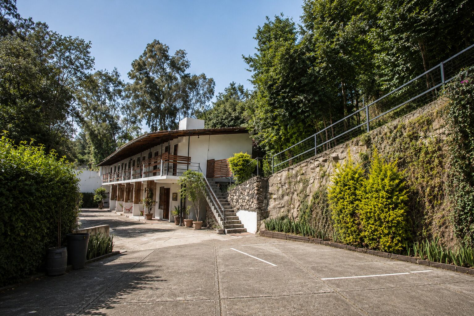 A building with a stone wall and a staircase leading to a balcony.