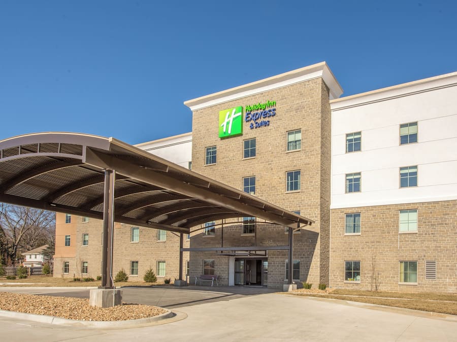 A Holiday Inn Express & Suites building with a covered entrance and a brick facade.