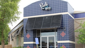 A building with a blue and beige facade, featuring the name "Paulo and Bill" prominently displayed at the top.