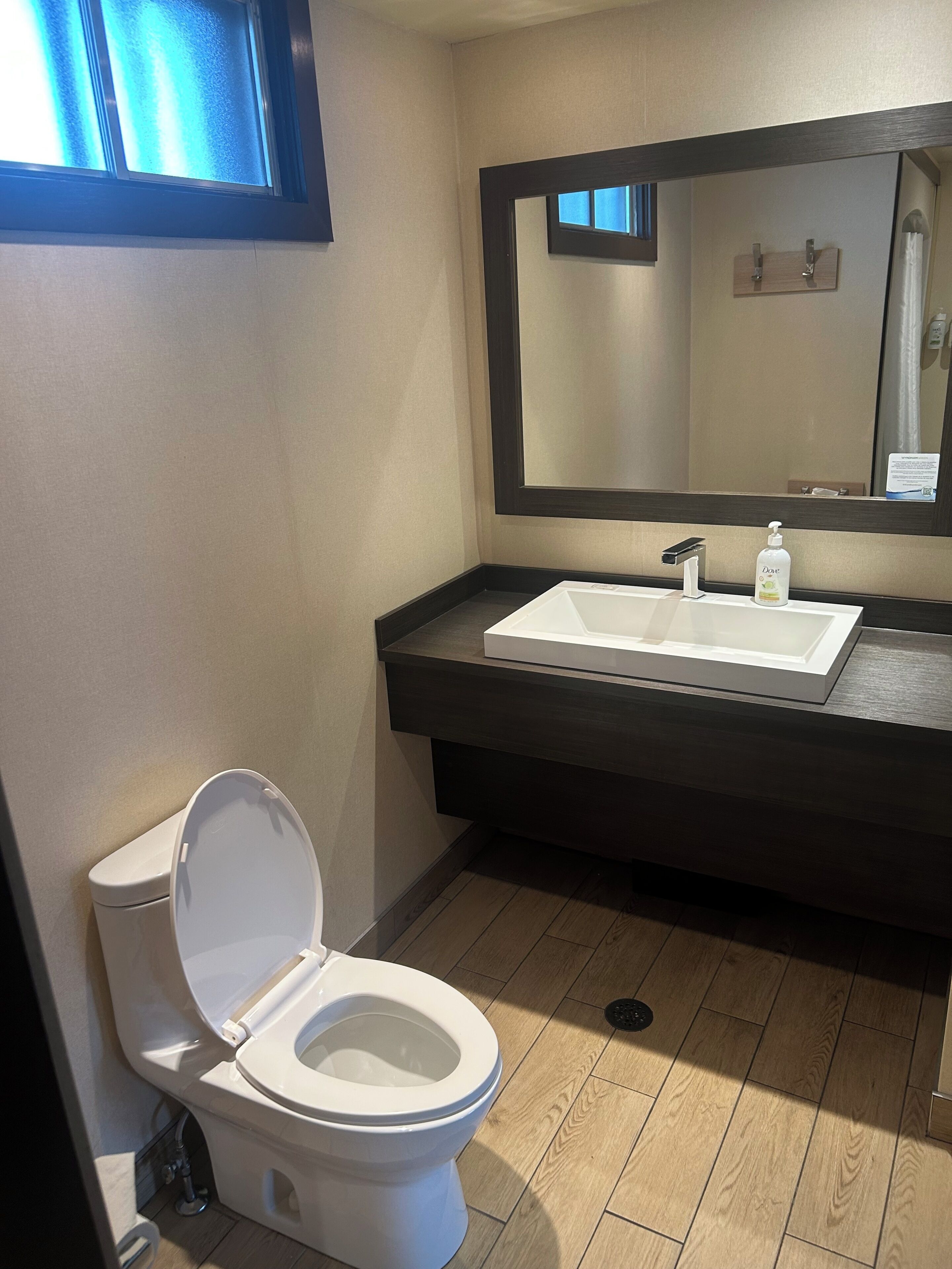 A modern bathroom with a toilet, sink, and mirror.
