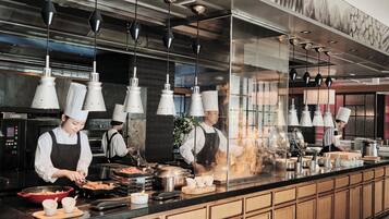 A modern kitchen with stainless steel appliances, wooden cabinets, and hanging pendant lights.