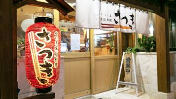 Perinteinen japanilainen lyhty, jossa on kiinalaisia kirjoitusmerkkejä, puinen sisäänkäynti ja kyltti, jossa on japanilaisia kirjoitusmerkkejä.