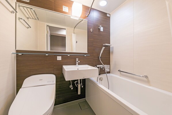 A modern bathroom with a toilet, sink, and bathtub.