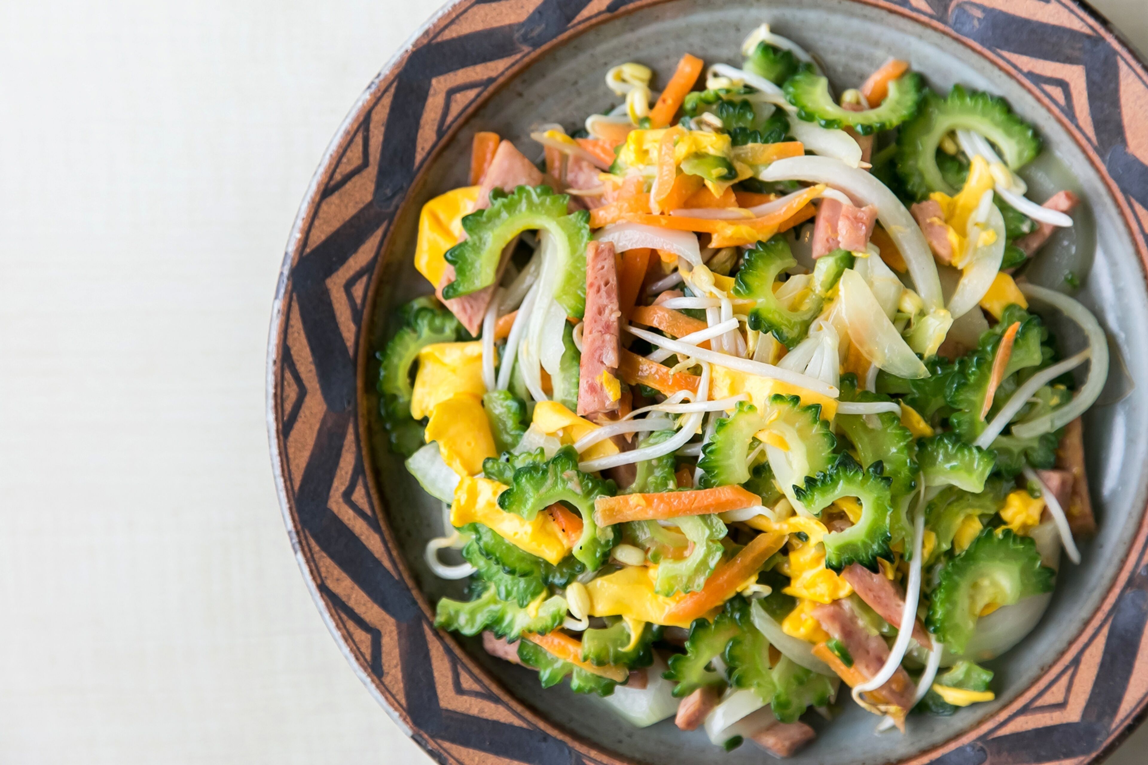 A bowl of salad with various vegetables and eggs.