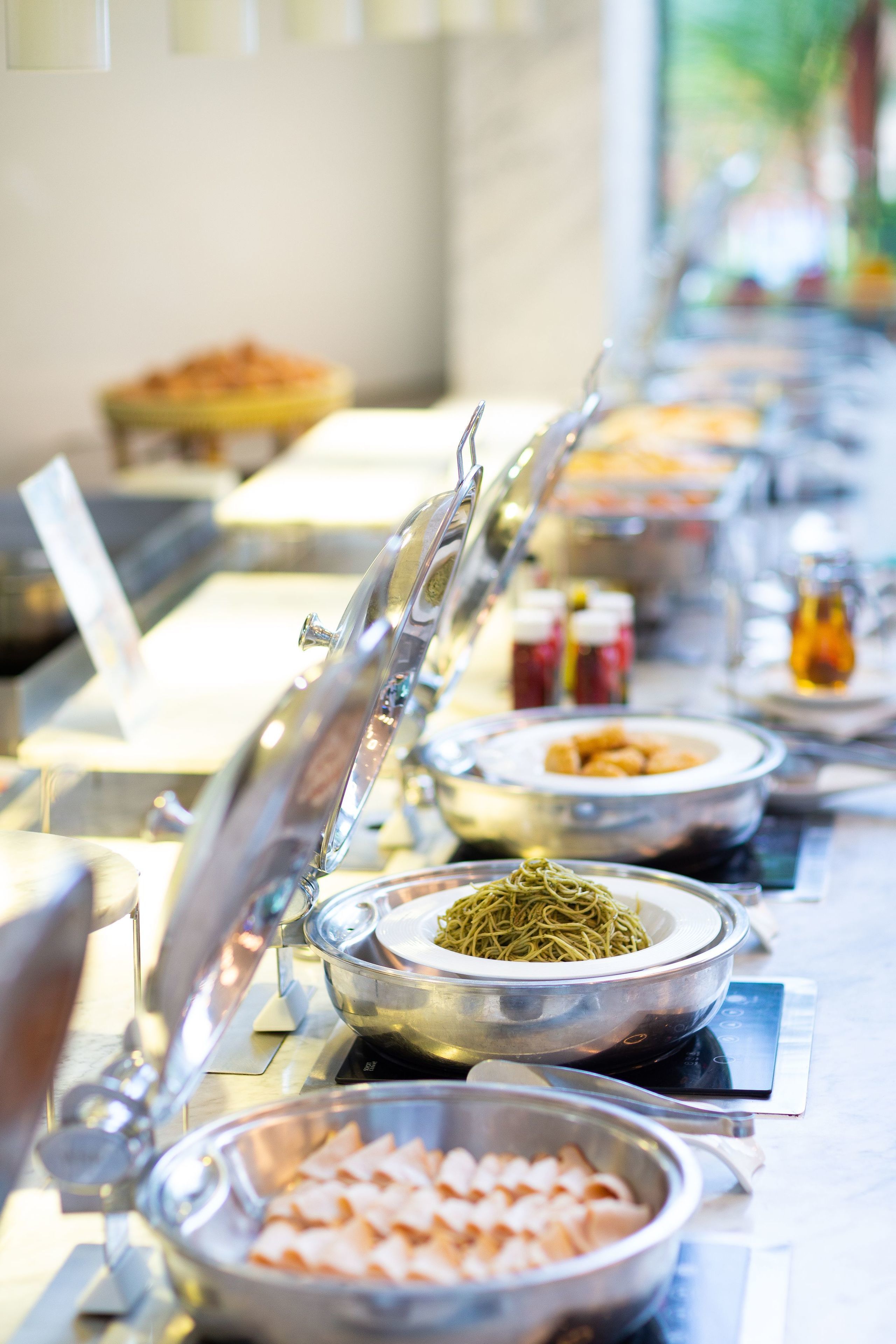 A buffet line with various food items and utensils.