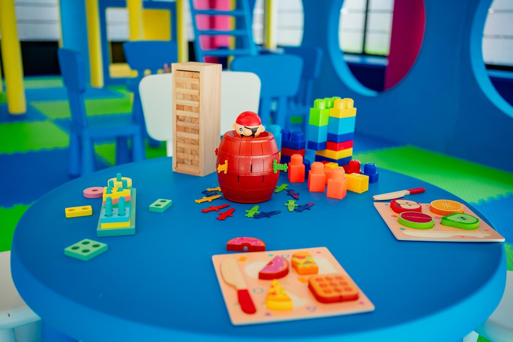 Un espace de jeux coloré avec une figurine, des blocs de construction et des jouets éducatifs.