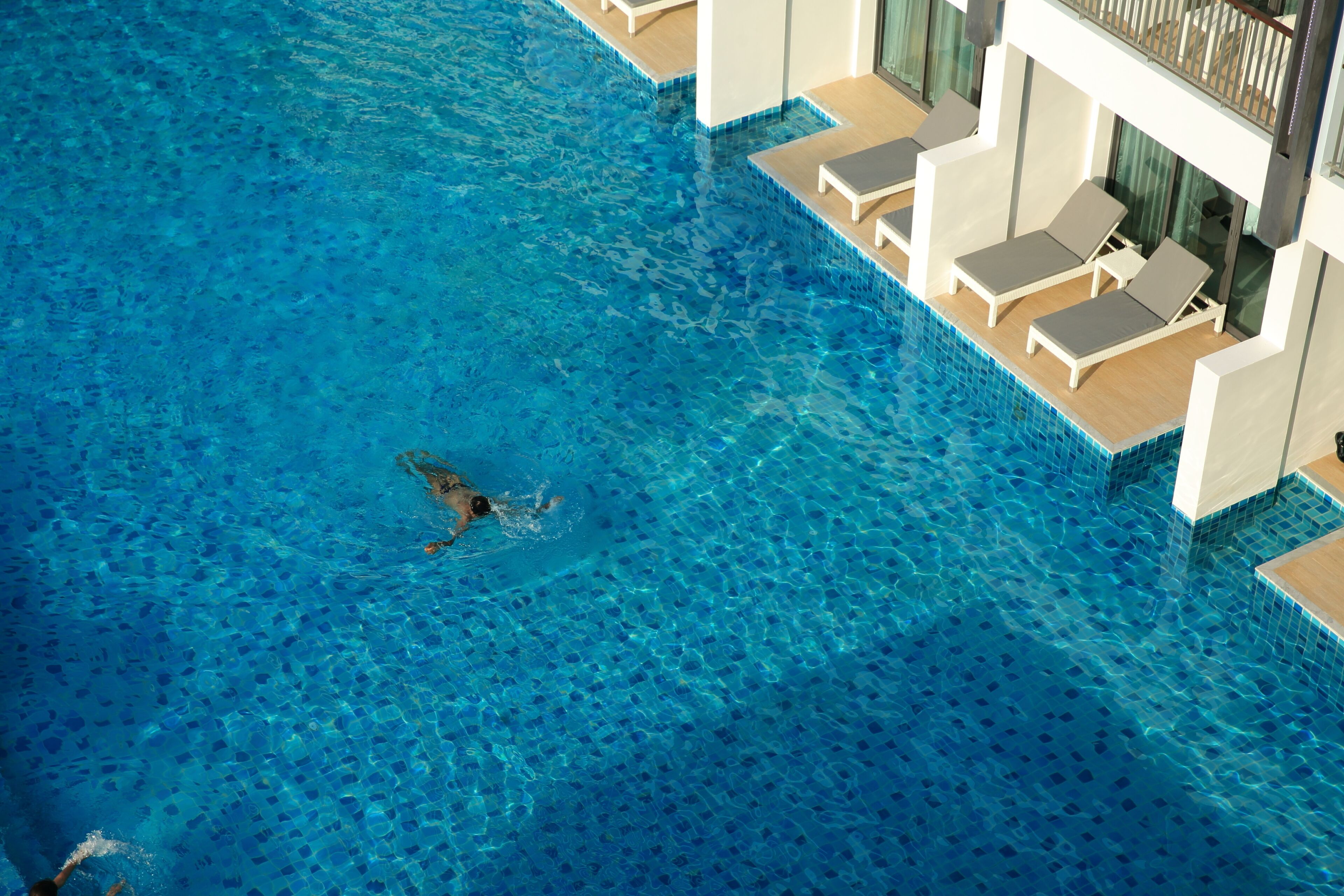 Una piscina al aire libre, sombrillas, tumbonas