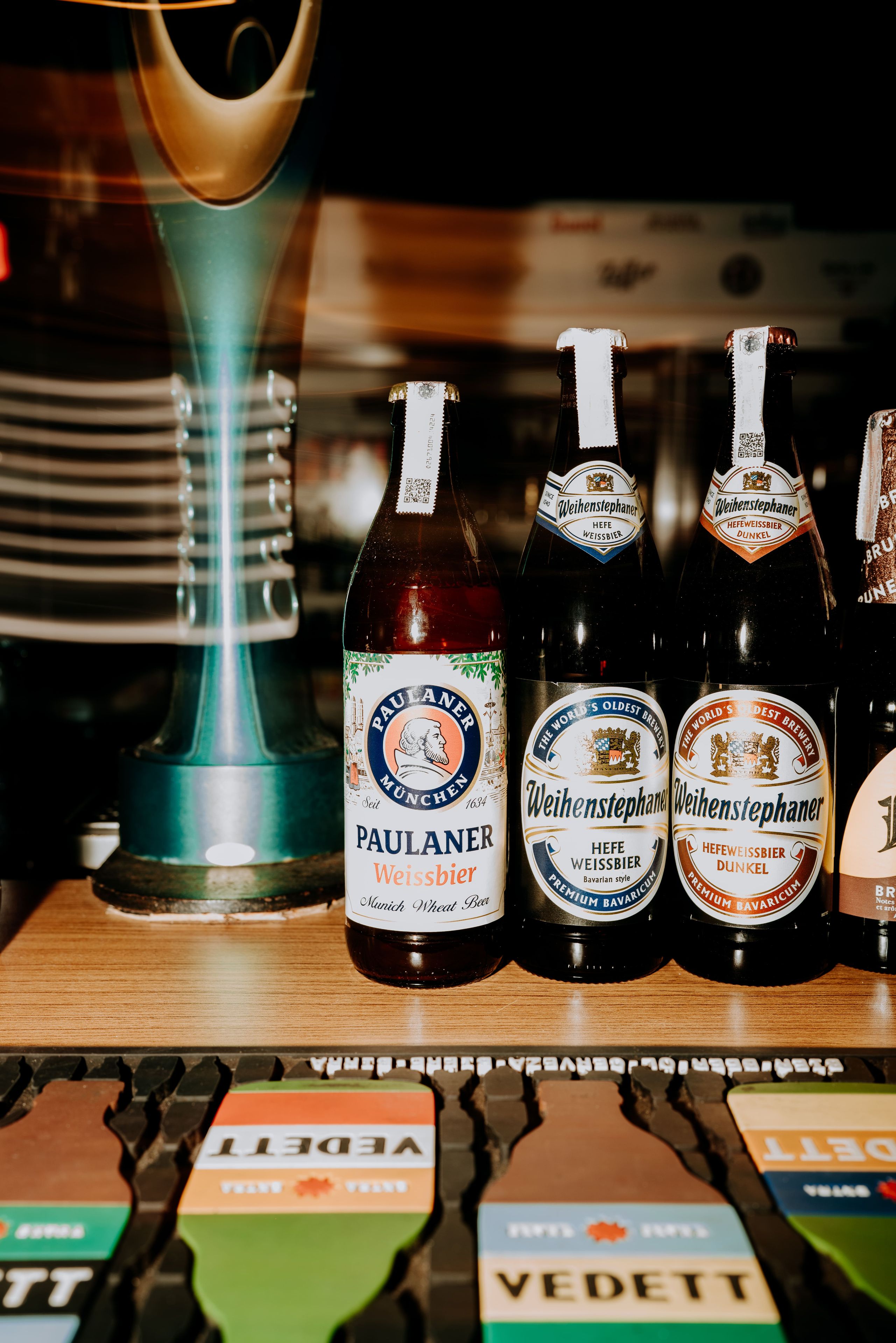 Een aantal bierflesjes op een houten ondergrond.