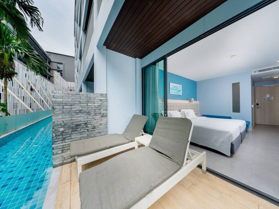A modern hotel room with a pool, a bed, and a bathroom.