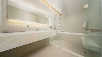 A modern bathroom with a large mirror, two sinks, a shower, and a glass-enclosed walk-in shower.