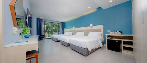 Una habitación de hotel moderna con dos camas, un escritorio y una pequeña cocina.