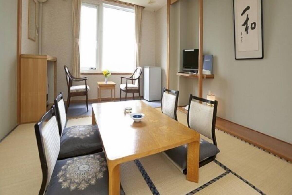 A traditional Japanese-style room with tatami flooring, a low wooden table, and shoji screens.