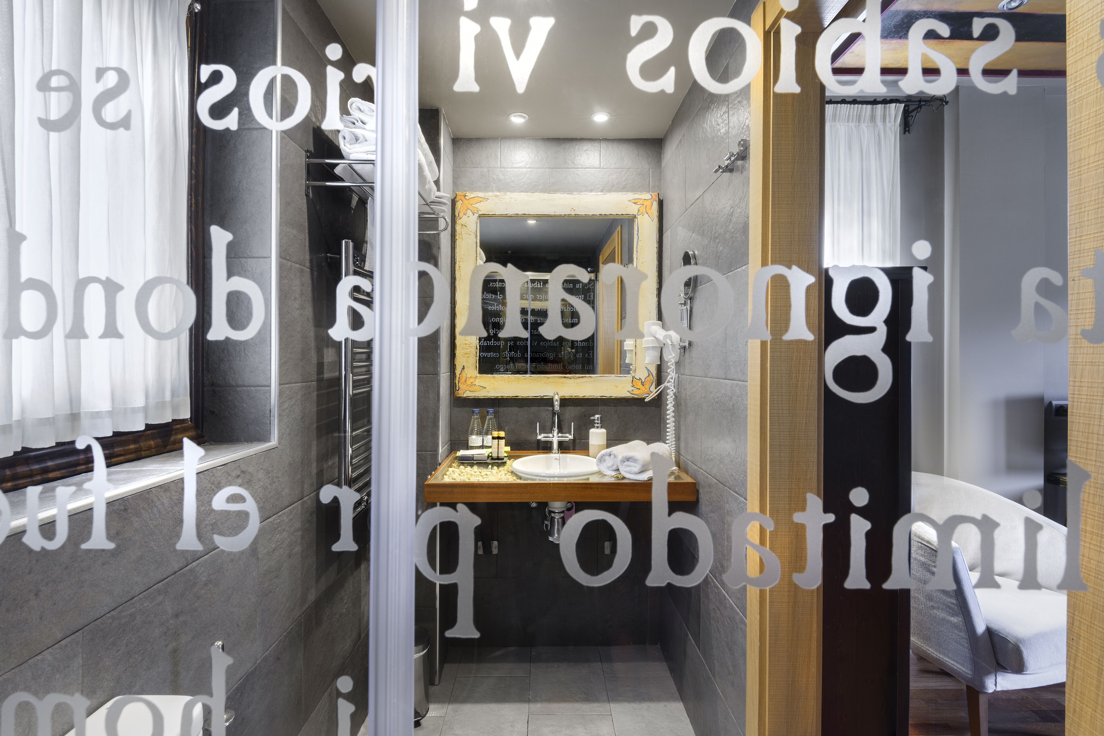 Un baño moderno con un tocador de madera, un espejo grande y una zona de ducha.