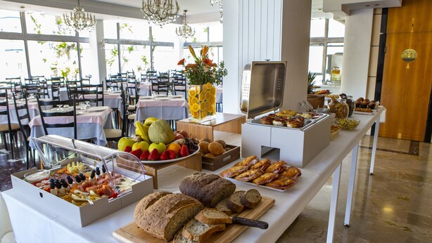 Montaje de bufé con diferentes alimentos y un centro de mesa decorativo.