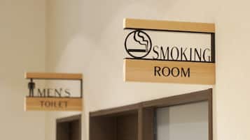 Signs for a smoking room and a men's toilet.