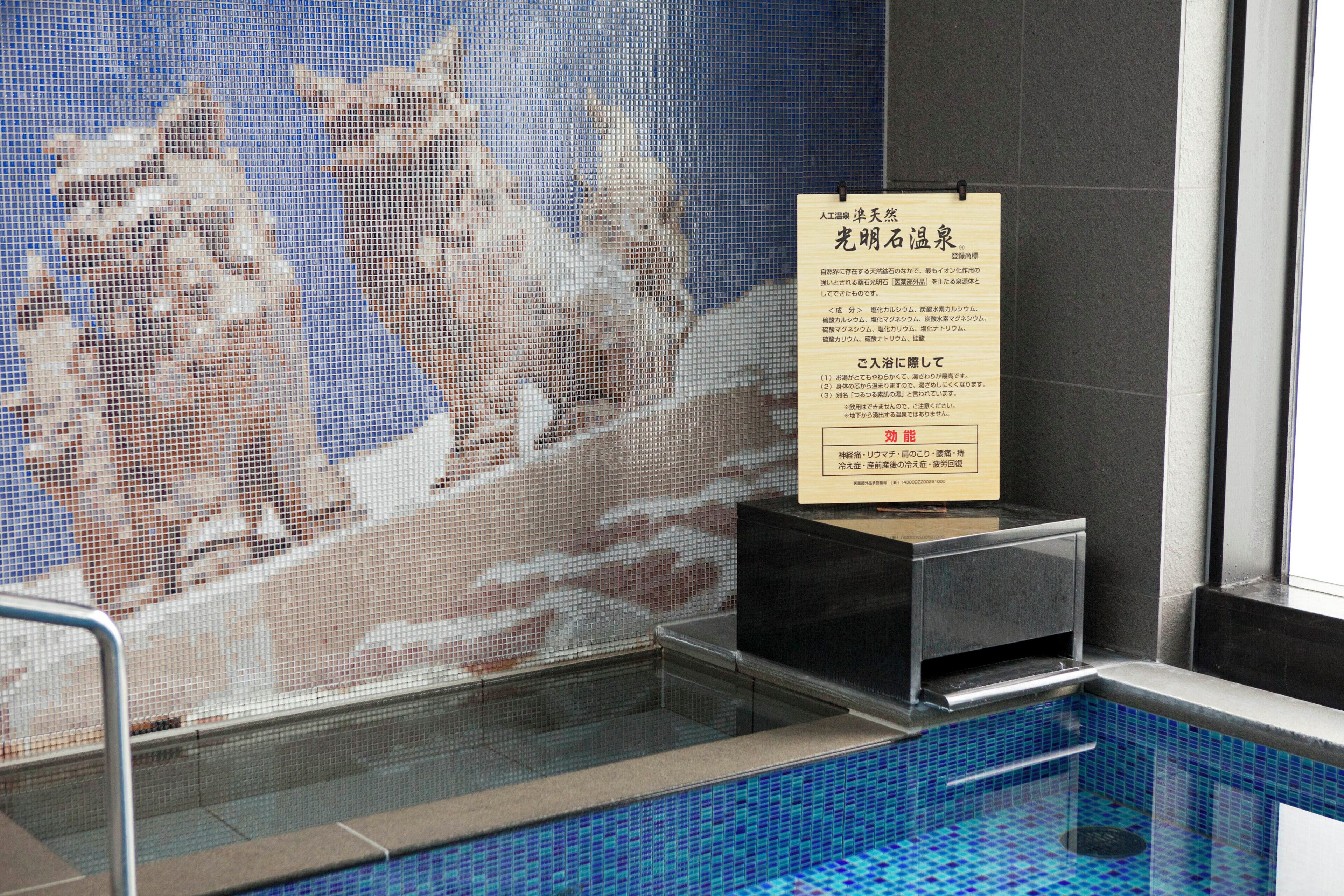 A pool area with a tiled wall and a sign.