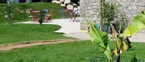 Een stenen gebouw met een gazon, een tuinhuisje en een fiets.