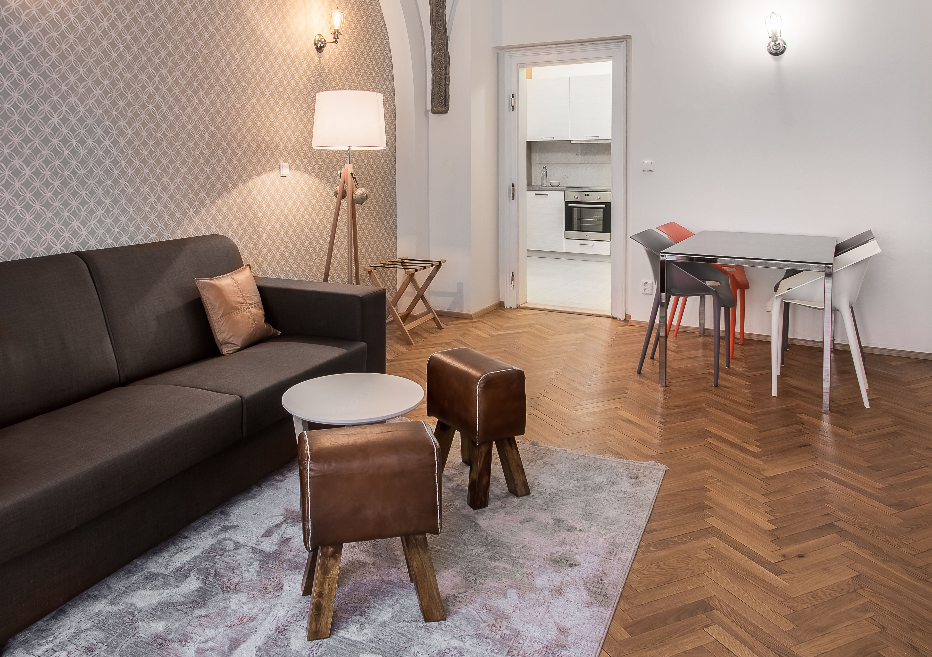 Un salon moderne avec un canapé, une table basse et un tapis. On y trouve également un coin repas avec une table et des chaises.