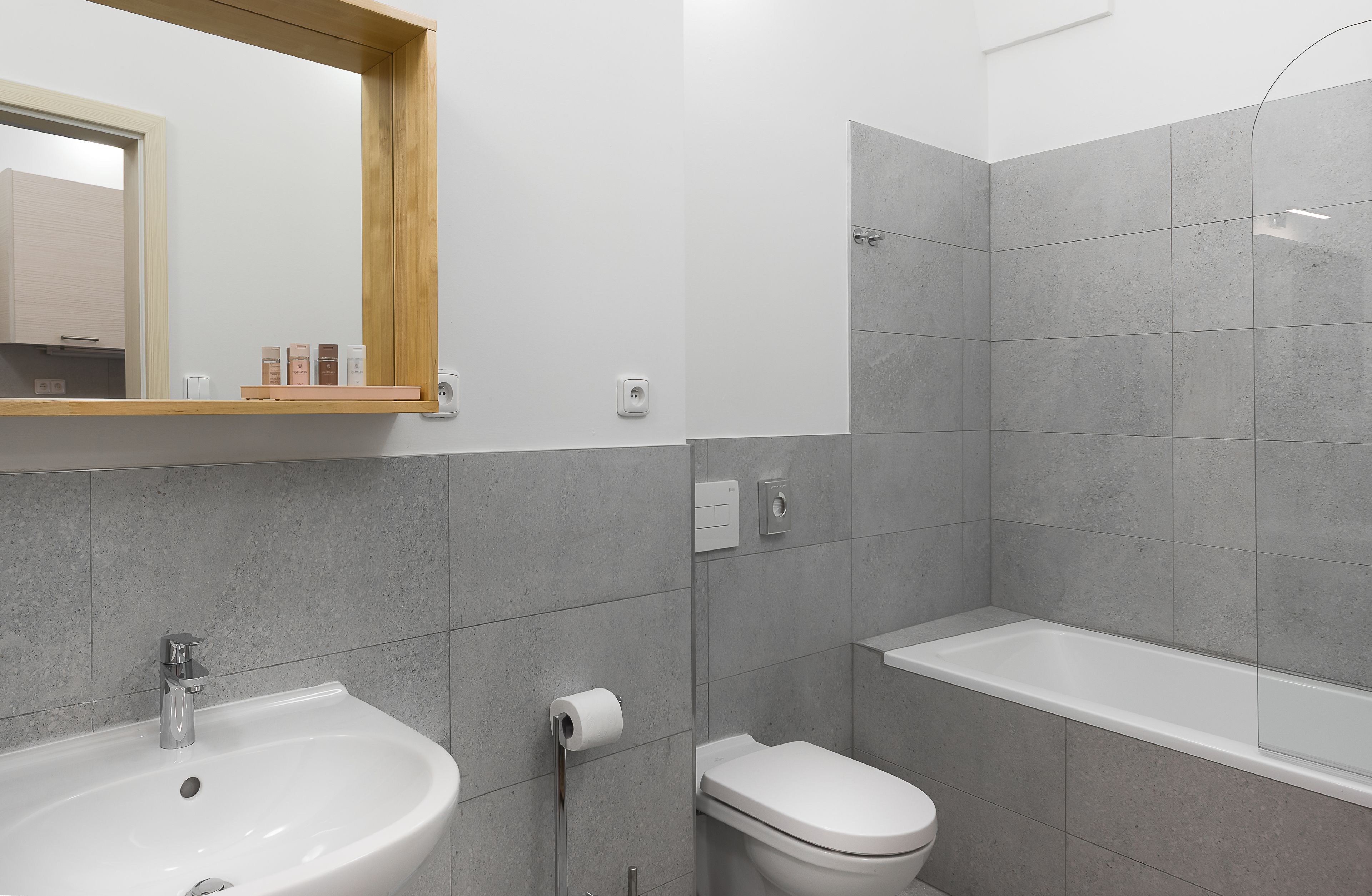Une salle de bain moderne avec un lavabo, des toilettes et une baignoire.