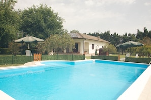 Una piscina con una casa al fondo.