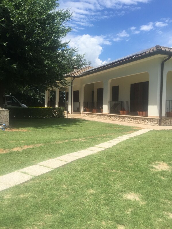 Un patio cubierto con un sendero de piedra que conduce a un edificio con techo de tejas.
