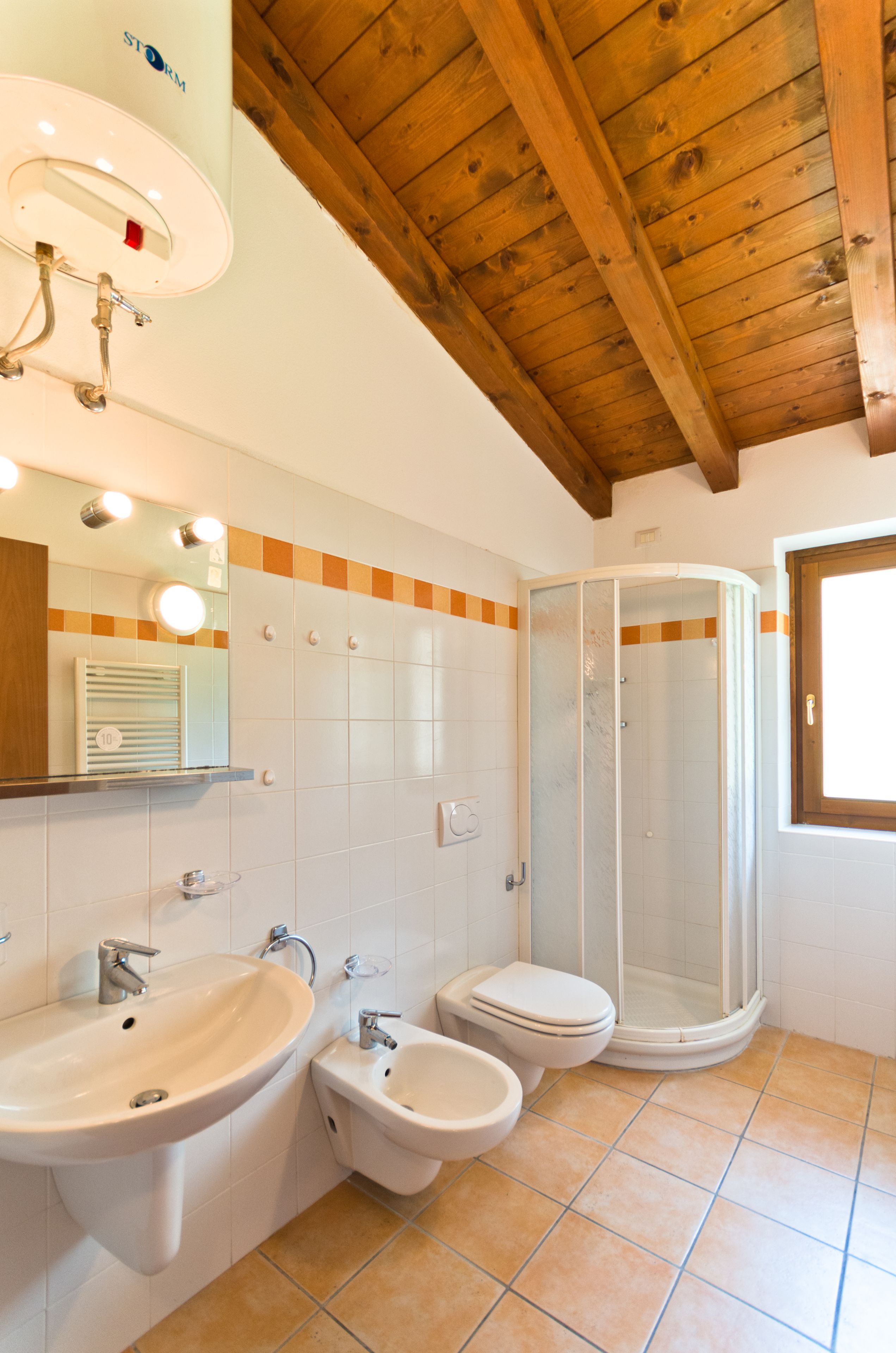 Une salle de bain équipée d’une douche, d’un lavabo, d’un bidet et de toilettes.
