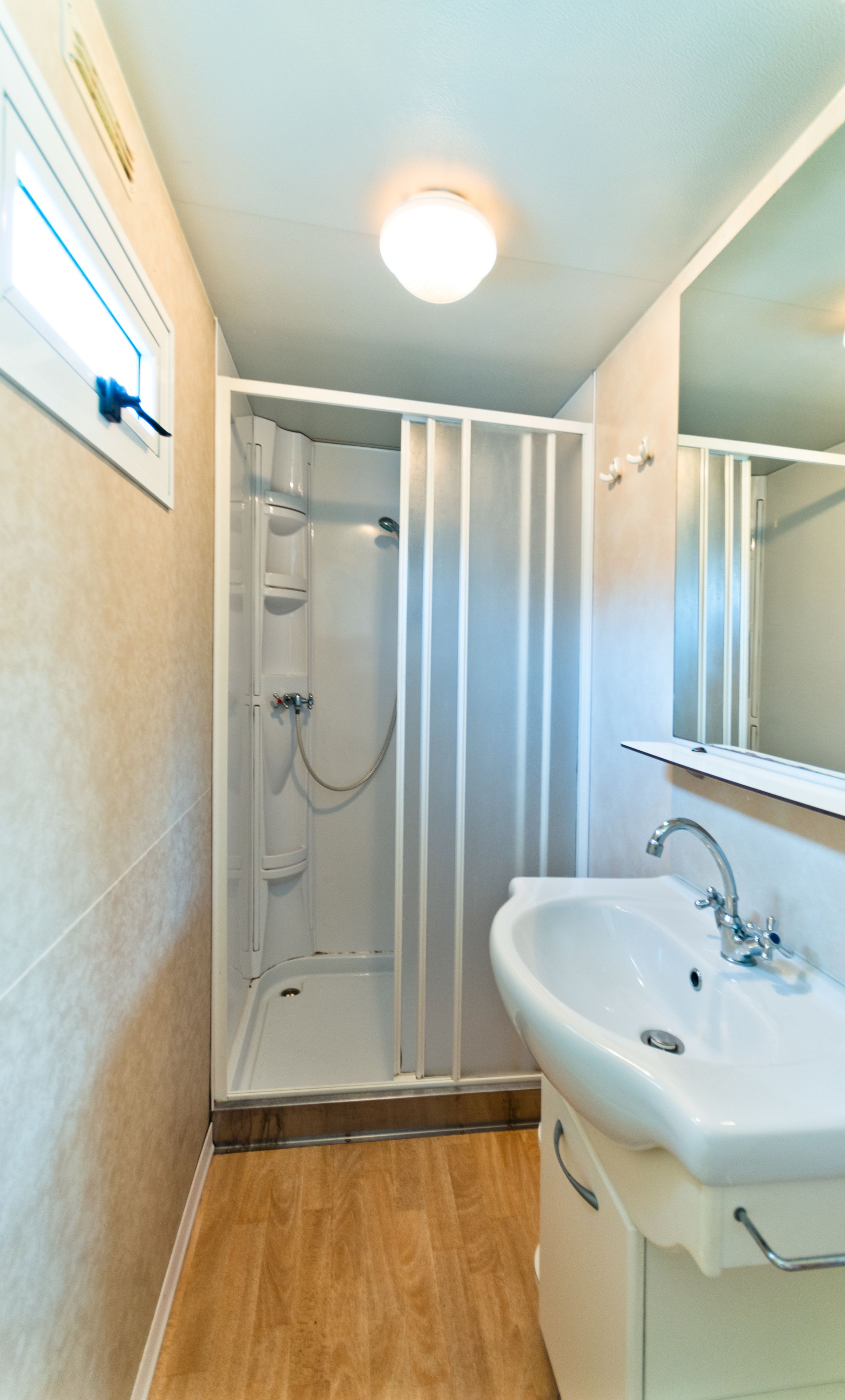 Ein modernes Badezimmer mit Duschkabine, Waschbecken und Spiegel.