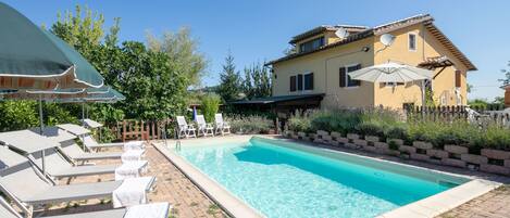 Piscina externa sazonal, funciona das 10h às 20h, guarda-sóis