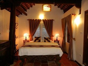 A bedroom with a bed, two bedside tables, a chandelier, and curtains. - Moon Garden Homestay (Hanoi)