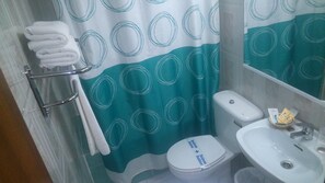 Een badkamer met toilet, wastafel en handdoekrek.