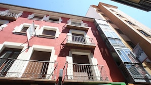 A multi-story building with balconies, windows, and a sign indicating a hotel. - Boutique Hotel Castilla (Soria)