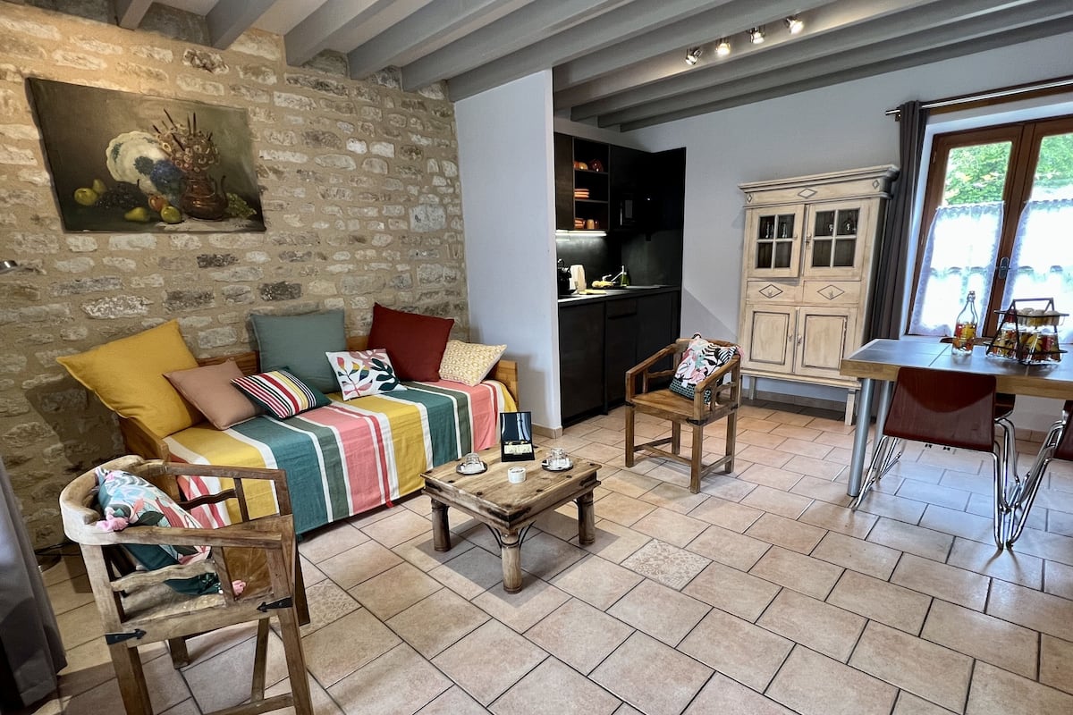 Un salon confortable avec un canapé, des fauteuils, une table basse et un coin repas comprenant une table et des chaises.